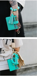 Detail of teal silicone bead keychain bracelet with PU leather card holder and tassel