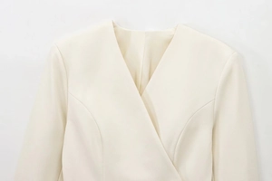 Detailed close-up of a V-neck elegant beige blazer showing fine fabric texture and seams