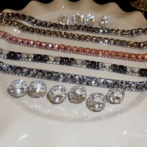 Close-up of square zircon earrings and bracelets set on a luxury jewelry display tray