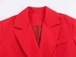 Detail of red blazer notched lapel and chest pocket with fine woven fabric texture
