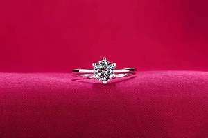 Macro view of classic six-prong solitaire ring with brilliant cut stone on red velvet