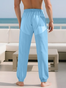 Detail of light blue checkered trousers featuring an elastic waistband and outdoor leisure style