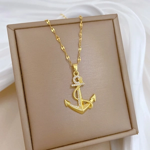 Détail du pendentif ancre dorée avec texture corde et cristaux transparents