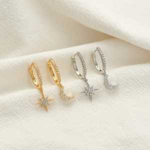 Macro shot of gold and silver star and moon earrings with pavé cubic zirconia details