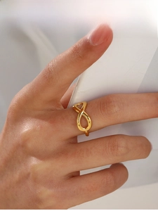 Detailed close-up of a gold infinity ring on finger showing polished finish and modern style