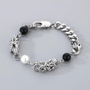 Detail of silver chain bracelet with black beads and a white pearl with lobster clasp