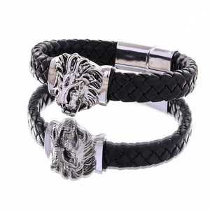 Close-up of men's black braided leather bracelet with silver lion head and magnetic clasp