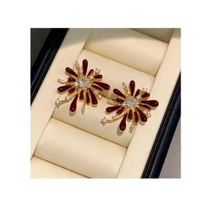 Macro shot of red enamel firework stud earrings with heart-shaped zircon in a jewelry box