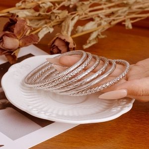 Set of minimalist silver stainless steel bangles with textured patterns for women