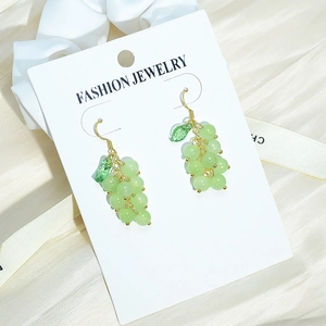 Fresh green grape tassel earrings with gold leaf and translucent beads on silk background