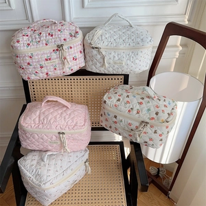 Detailed close-up of quilted cotton cosmetic bags with bear and cherry prints on a chair