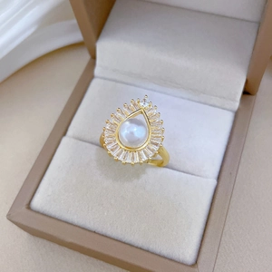 Detail of luxury gold ring with center pearl and radiant square-cut cubic zirconia