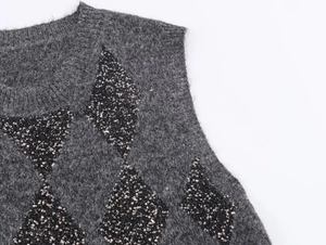 Detailed macro view of dark grey knit vest featuring sequined argyle patterns and fuzzy texture