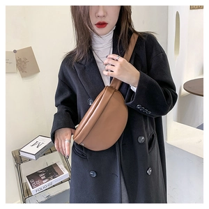 Detail view of a brown minimalist leather belt bag shown on model for a stylish look