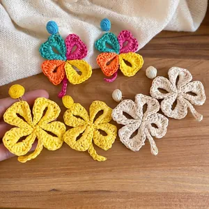 Handmade raffia flower clover earrings in colorful, yellow, and cream woven designs