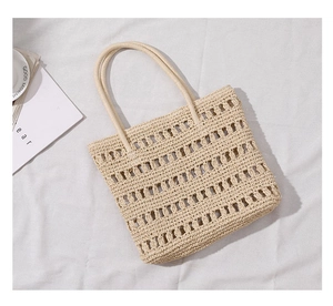 Detailed close-up of beige hollow woven straw handbag for summer beach vacation style