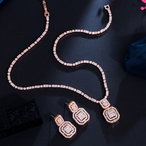 Macro shot of rose gold jewelry set featuring square zircon necklace and earrings