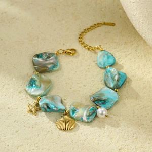 Detailed view of ocean style gold bracelet with starfish, seashell, and blue stone charms