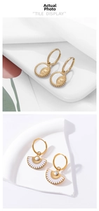 Detail of vintage gold-plated titanium steel earrings with fan and round sunburst patterns
