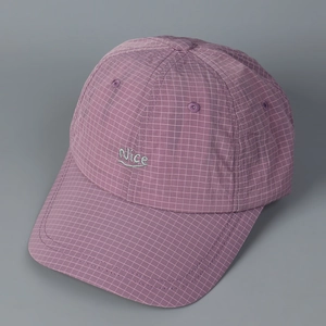 Macro shot of purple checkered baseball cap with small green Nice letter embroidery