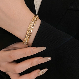Détail d'un bracelet géométrique vintage doré avec strass brillants sur un mannequin