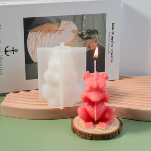 Detail of a silicone dragon candle mold with a pink finished candle on a wave display