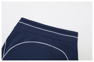 Détail des coutures contrastées flatlock sur la taille du legging de yoga bleu marine
