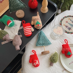 Detail of handmade knit Christmas tree and miniature festive gloves with reindeer patterns