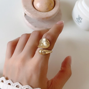 Minimalist double-layered gold lava ring with irregular textured finish on finger