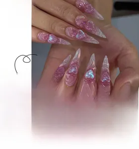 Detail of extra-long stiletto nails with 3D pink hearts and marble texture patterns