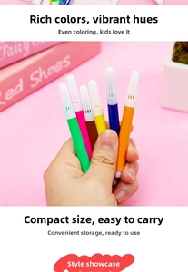 Close-up of hand holding a compact multi-color watercolor pen for portable drawing