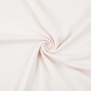 Macro d'un tissu en maille douce avec pliage en spirale élégant en rose pâle