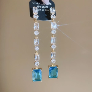 Detail of 18K gold plated long tassel earrings with blue zircon and 925 silver studs