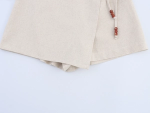 Dettaglio del tessuto in cotone-lino bianco avorio con coulisse e perline decorative