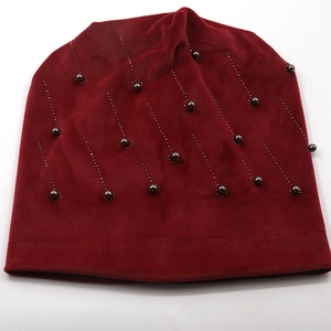 Detailed view of burgundy velvet beanie featuring vertical rhinestone and bead embellishments