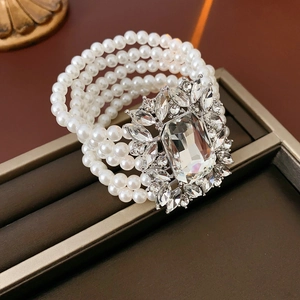 Detailed macro shot of a multi-layer pearl bracelet with a large square rhinestone centerpiece