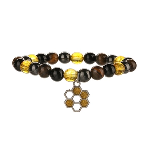 Détail de perles en citrine naturelle et œil de tigre avec un pendentif abeille doré
