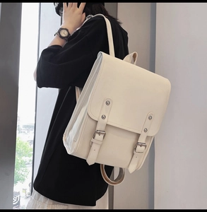 Side view of a vintage beige soft leather backpack with stylish double buckle closure