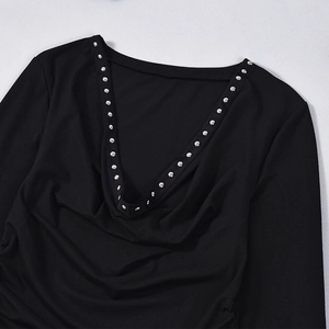 Close-up of black slim fit top featuring a deep V-neck and silver metal stud embellishments