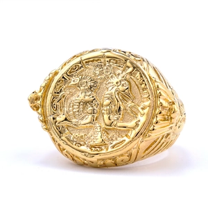 Macro shot of vintage gold-tone stainless steel ring with relief coin and ancient totem
