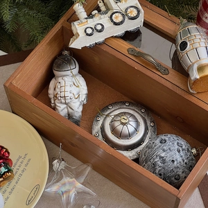Close-up of astronaut, rocket and UFO resin ornaments in a vintage wooden gift box