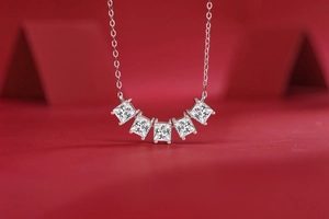 Detailed view of 925 sterling silver necklace with five princess cut moissanite stones