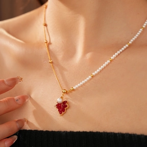 Détail du collier plaqué or 18 carats avec pendentif feuille rouge et perles élégantes