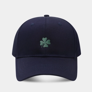 Close-up of green clover embroidery on dark blue cotton twill baseball cap