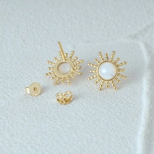 Detail of S925 sterling silver opal stud earrings with gold sunburst design and back engraving