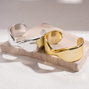 Minimalist geometric twisted open cuff bracelet in polished gold and silver finish