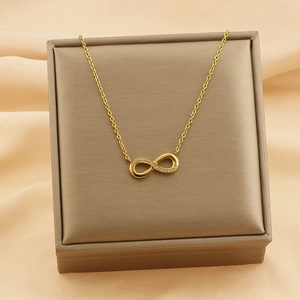Detail of 18k gold infinity necklace with sparkling diamonds on a silk background