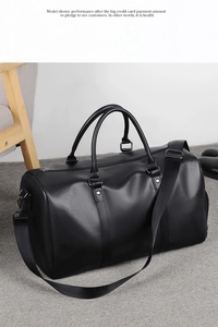 Detail shot of large black leather gym bag with litchi texture and adjustable strap