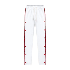 Detail of white men's trousers featuring side red plaid stripes and decorative snap buttons
