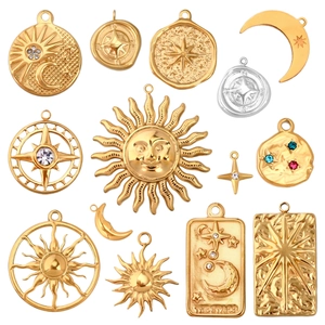 Detail of celestial gold charms including sun, moon, and star pendants with crystals